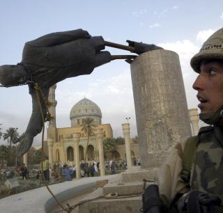 REGIMESKIFTE: I det legendariske bildet til Reuters-fotograf Goran Tomasevic ser den amerikanske marinesoldaten Kirk Dalrymple p� n�r statuen av Saddam Hussein faller. Og britene planla ogs� et regimeskifte i Irak, stikk i strid med det Tony Blair sa. Foto: REUTERS/Goran Tomasevic/Scanpix
