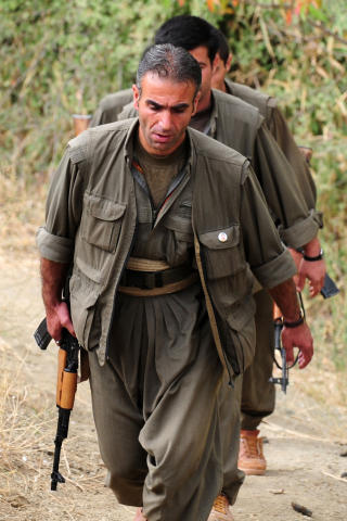 STRENGT BEVOKTET: PKK-ledren Mirat Karayilan ble eskortert til intervjuet av v�pnede PKK-soldate. Foto: AFP/MUSTAFA OZER