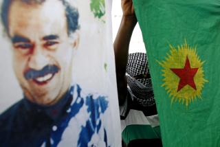 SITTER FENGSLET: PKK-leder Abdullah Ocalan ble arrestert av tyrkiske myndigheter i 1999. Her en plakat av ham og det kurdiske flagget i en demonstrasjon i Diyarbakir i Tyrkia. Foto: EPA/TOLGA BOZOGLU