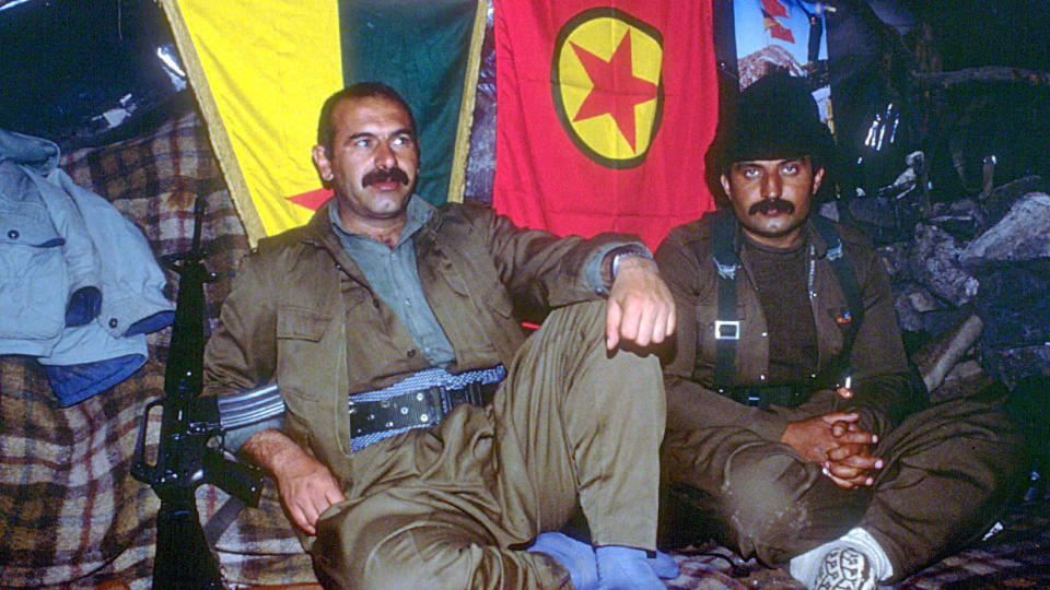 HAR PLANER OM � DRA TIL TYRKIA: If�lge tyrkisk presse har PKK-leder Abdullah Ocalans bror Osman Ocalan (til venstre) planer om � overgi seg, if�lge tyrkisk presse. Han oppholder seg i Nord-Irak, men har r�ket uklar med lederne i PKK, og har antakelig lite st�tte blant folk. Her er han avbildet sammen med en ikke navngitt PKK-oppr�rer i en leir i Nord-Irak i 1998. Foto: AP /Hurriyet