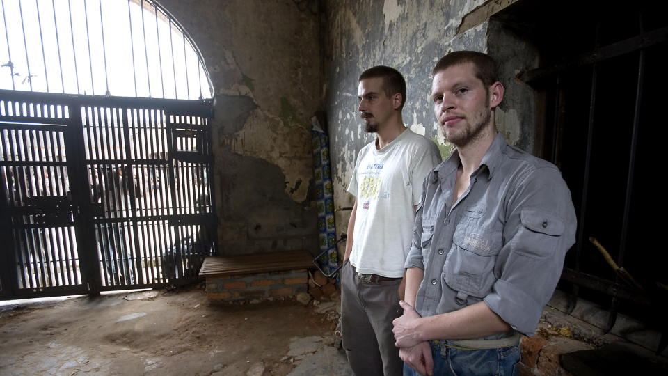 D�dsd�mte: Joshua French (t.h.) og Tjostolv Moland  har sittet fengslet i Kongo siden mai 2009. Her er de fotografert i mellomgangen mellom de to jernportene inn til fengselet i Kisangani, der de sitter fengslet d�mt for spionasje og drap p� sj�f�ren sin i Kongo.   Foto: Tore Bergsaker