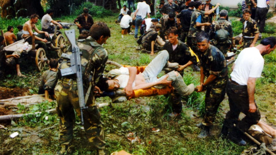 MASSAKRE: Dette bildet fra 1995 viser s�rede og d�de i Srebrenica. En s�ret person b�res p� b�re av fire soldater.
Bildet er scannet inn, stemplet med dato 19950723.

Foto: Ukjent/Scanpix