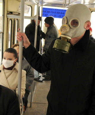 GASS ELLER INFLUENSA: En ung mann har p� seg en gassmaske om bord p� bussen i Lviv vest i Ukraina. Foto: YURIY DYACHYSHYN/AFP