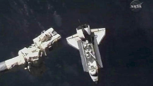 SAAAKTE: Atlantis n�rmer seg ISS under den tidkrevende og ekstremt n�yaktige sammenkoblingsoperasjonen. Til venstre ser du ISS' robotarm. Foto: REUTERS/NASA TV/SCANPIX