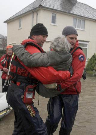 F�R HJELP: To redningsarbeidere l�fter en eldre kvinne i trygghet. Det er meldt mer regn i det flomrammede omr�det utover. Foto: REUTERS/Phil Noble/Scanpix