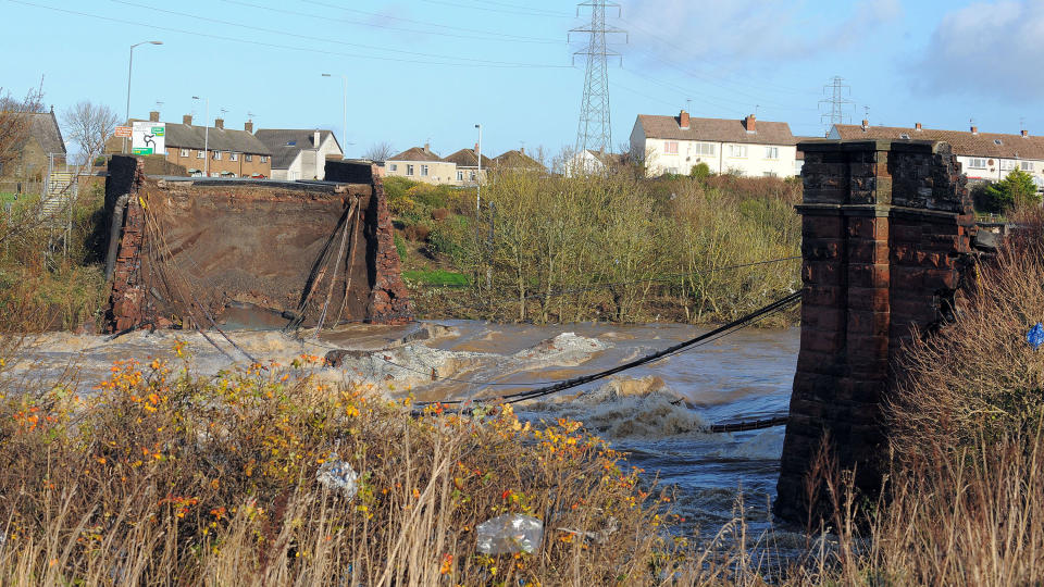 KOLLAPSET: Broen Northside Bridge i Workington nord i England kollapset tidligere i dag. Politimannen Bill Barker (44) sto p� broen da den brast og ble med de enorme vannmassene. Politimannen ble funnet omkommet flere timer senere. Foto: AFP ANDREW YATES/SCANPIX