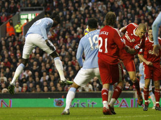 STREK I REGNINGA: Etter � ha tatt ledelsen, ga Liverpool den enkelt fra seg da Emmanuel Adebayor uhindret fikk g� opp og heade inn utligningen. Foto: SCANPIX/AFP PHOTO/IAN KINGTON
