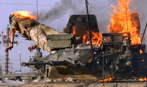 BLODIG: En britisk soldat kaster seg ut av stridsvognen han satt i etter at en folkemengde angrep den i Basra i 2005. Reuters-fotograf Atef Hassans ber�mte bilde er blitt et symbol p� kritikken mot britenes krigf�ring i Irak. Foto: REUTERS/Atef Hassan/Scanpix
