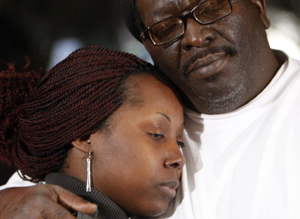 S�RGER: Den d�des bror, David Johnson, holder rundt Deangela Johnson, Cecile Johnsons datter. Foto: AP Photo/Mark Humphrey/Scanpix