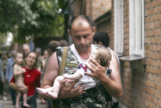 BESLAN: En russisk politimann b�rer ut en baby som var p� skolen som ble angrepet av terrorister i Beslan i september 2004. Hundrevis ble holdt som gisler i skolen, men noen f� fikk slippe fri f�r. Etter tre dager var gisseldramaet over, minst 338 mennesker ble drept, hvorav 155 barn. Foto: REUTERS/Viktor Korotayev