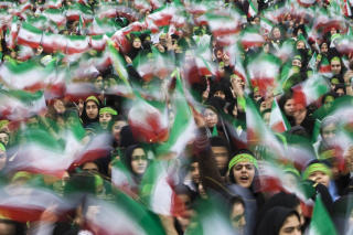 OMRINGET UNIVERSITETET: Bildet viser studenter som vifter med iranske flagg under et massem�te tidligere i �r. Oppr�rspoliti har omringet universitetet i Irans hovedstad Teheran, etter rykter om at opposisjonen i landet ville fors�ke � forstyrre et massem�te til st�tte for regjeringen. Tilgangen til internett er ogs� stengt, og utenlandske mediefolk har f�tt reportasjeforbud. Arkivfoto: REUTERS / Raheb Homavandi / SCANPIX
