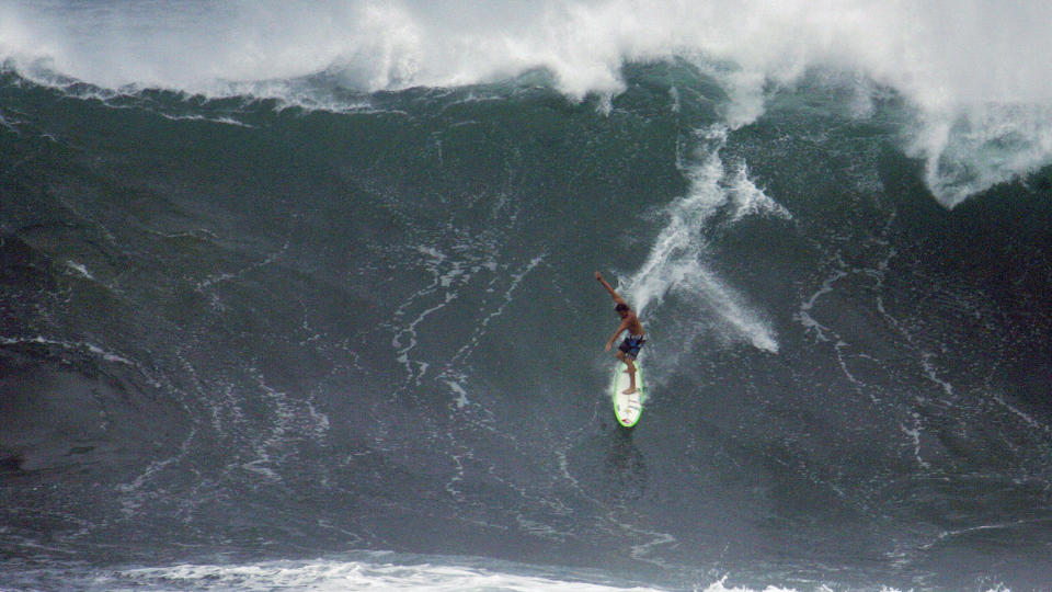 MONSTERB�LGE: Den profesjonelle surferen Reef McIntosh ga seg i kast med noen av kjempeb�lgene som krasjet inn over Waimea Bay p� nordkysten av Oahu i Haleiwa, Hawaii i g�r. B�lgeh�yden er ventet � toppe seg senere i dag, og fortsette igjennom onsdagen. Foto: REUTERS/Hugh Gentry