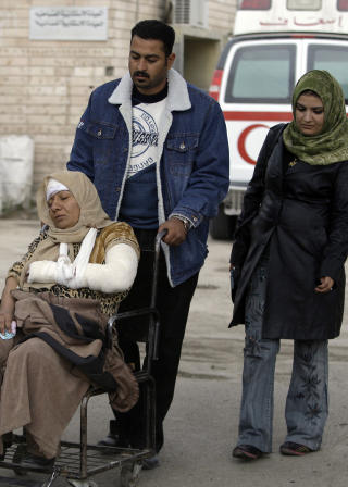 TIL SYKEHUS: En mann ruller moren sin til sykehus i Bagdad. Foto: AP/Karim Kadim
