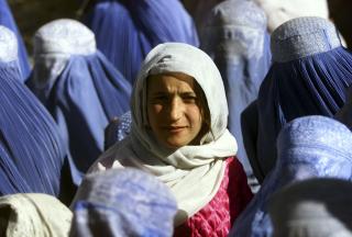 LA EN EKSTREM VARIANT AV SHARIA TIL GRUNN: Her titter en ung, afghansk kvinne opp fra burkaen for f�rste gang, etter fem �r med Talibans sharialover. Bildet er tatt i november 2001. Foto: REUTERS/Yannis Behrakis