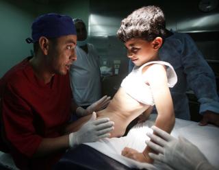 OMSKJ�RING P�BUDT: B�de de islamske sharia-lovene og de j�diske halakha-lovene regulerer omskj�ring av gutter. Dette bildet er fra et sykehus i Algerie, hvor kirurgen fors�ker � berolige gutten f�r omskj�ring. Foto: REUTERS/Zohra Bensemra