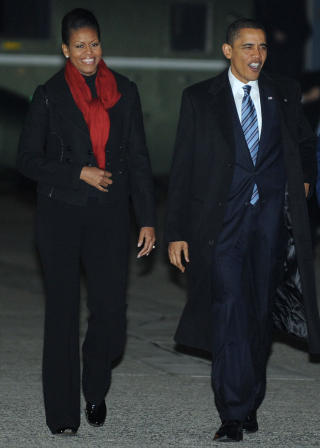 VINTERLIG KLEDD: B�de Michelle og Barack Obama ser ut til � ha kledd seg for det norske klimaet. Michelle med svart bukse, en kort svart jakke og et r�dt skjerf ved avgang fra USA. Foto: AFP/Scanpix