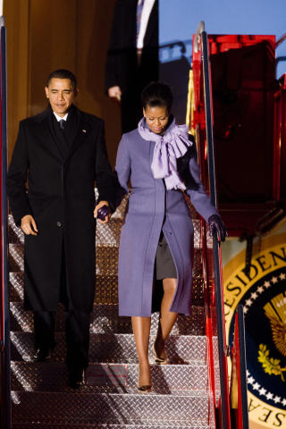 GJENNOMF�RT: Michelle Obama er gjennomf�rt med lilla k�pe, skjerf og hansker. 
Foto: Heiko Junge / Scanpix