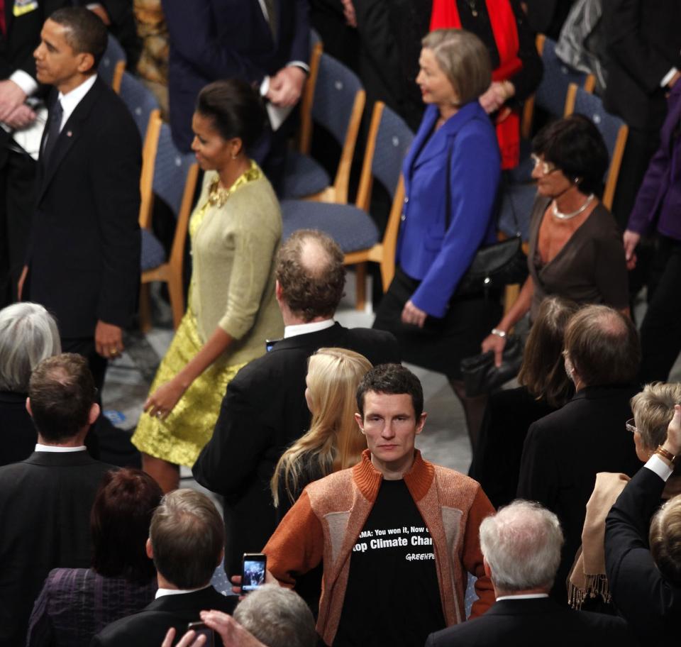 KASTET UT: Truls Gulowsen i Greenpeace pr�vde � aksjonere i r�dhuset. Han ble kastet ut. Her st�r han midt i forsamlingen, Barack og Michelle Obama i bakgrunnen. Foto: Fredrik Naumann.
