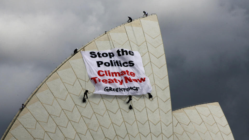 BESTEG OPERAEN: Klatrende Greenpeace-aktivister har plassert et banner med oppfordring om en �yeblikkelig klimaavtale p� operahuset i Sydney. Foto: REUTERS/SCANPIX