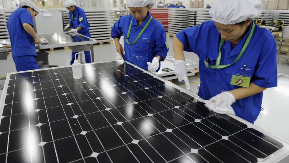 SOLCELLEPANEL: Arbeidere i Kina inspiserer det ferdige produktet. Foto: SCANPIX