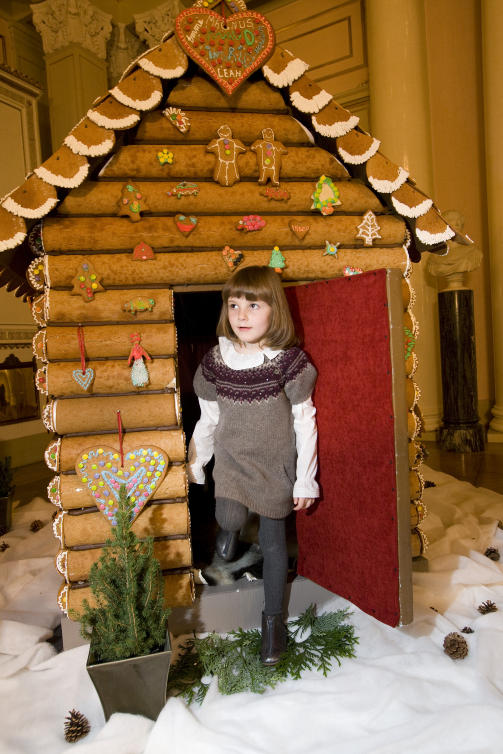 GEDIGENT PEPPERKAKEHUS: Prinsesse Ingrid Alexandra beundrer det store  pepperkakehuset da kongefamilien stilte opp p� tradisjonelle julefotograferingen p� Slottet torsdag. Foto: Terje Bendiksby / Scanpix