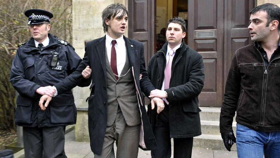 SLAPP FENGSEL: men ble arrestert igjen minutter etter at dommen falt. Her blir den britiske rockestjerna Pete Doherty marsjert bort til politistasjonen som ligger like over veien for retten. Foto: AP/SCANPIX