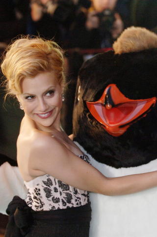 KLEM: Murphy klemmer en av pingvinene fra animasjonsfilmen �Happy Feet� under en premiere i London. Foto: KEITH HAMMETT / DAGBLADET