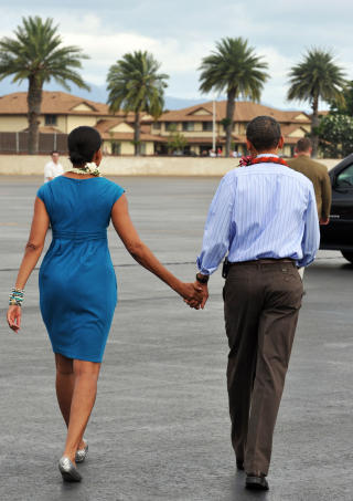 H�ND I H�ND:  Michelle og Barack Obama skal nye juleferien i varmen p� Hawaii. Foto: AFP PHOTO/Jewel SAMAD