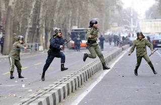 JAKT: Politimenn jager demonstranter i gatene i Teheran. Foto: AFP