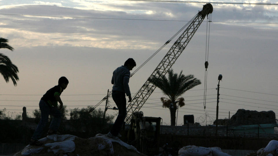 SPERRET INNE: Palestinere ser p� at en stor jernvegg blir bygd p� den egyptiske siden av grensa for � forhindre smuglertunneler fra Gazastripa. Foto: AFP PHOTO/SAID KHATIB/Scanpix