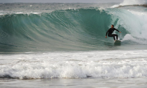 SURFER �RET INN:  En surfer utenfor Tel Aviv. Foto: SCANPIX/AP Photo/Ariel Schalit