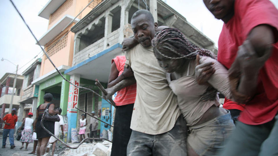  En kvinne f�r hjelp etter at 7,0-skjelvet p� Richters skala i g�r kveld la store deler av Haiti-hovedstaden Port-au-Prince i grus. D�dstallet er trolig flere tusen, i det som var det kraftigste skjelvet �ynasjonen har opplevd p� over 200 �r. Foto: AFP PHOTO/Lisandro SUERO/Scanpix