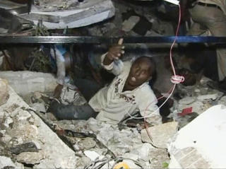 FANGET: En mann fanget i ruiner roper om hjelp i Port-au-Prince. Foto: REUTERS/Reuters TV/Scanpix