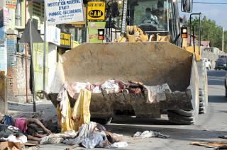 BRUKER BULLDOSER: En bulldoser flytter lik fra gata i Port-au-Prince. Foto: AFP PHOTO/Juan Barrato/Scanpix