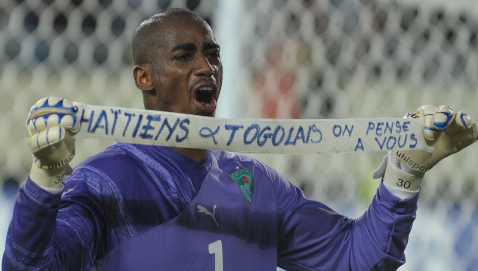 VISTE SIN ST�TTE: Hver gang Elfensbenskysten scoret mot Ghana, holdt keeper Boubacar Barry opp et banner med p�skriften �Haitianere og togolesere: Vi tenker p� dere� - en st�tteerkl�ring til jordskjelvofrene p� Haiti og det togolesiske fotballandslaget som ble angrepet p� vei til Afrikamesterskapet.  Foto: SCANPIX/AFP PHOTO / ISSOUF SANOGO