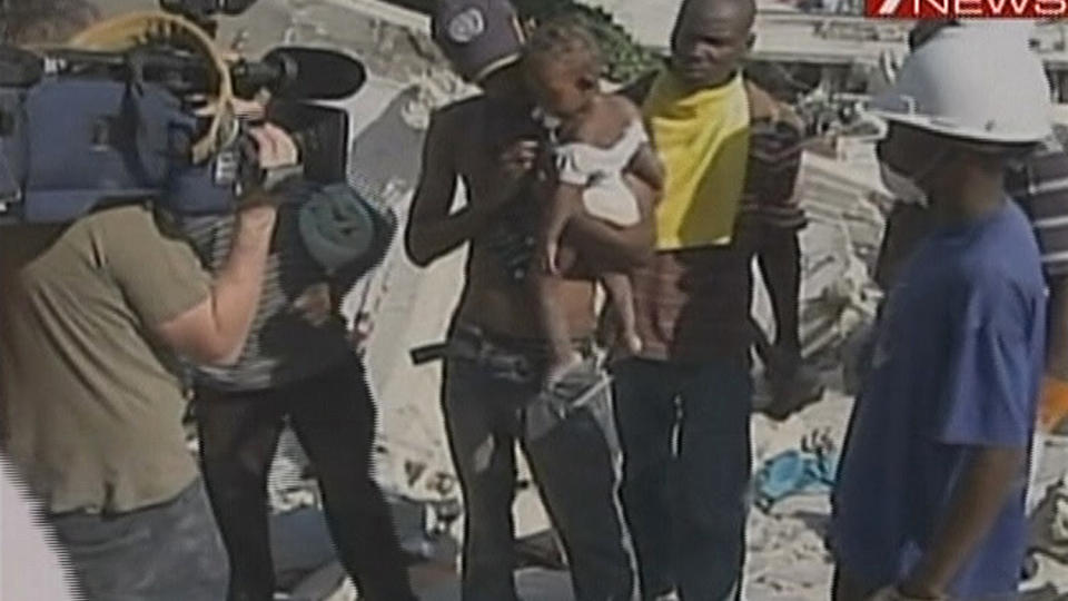  REDDET:  Lille Winnie er nettopp hentet ut fra ruinene, i hendene p� sin redningsmann Deiby Celestino, som var tolk for et australsk tv-team. FOTO: AP/CHANNEL 7/SCANPIX.