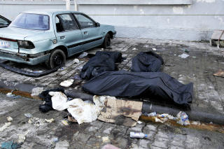MANGEL P� LIKPOSER: Hundre meter fra inngangen til det offentlige sykehuset i Port-au-Prince ligger flere lik. Disse er pakket inn i likposer, men flere andre er ikke det. FOTO: JACQUES HVISTENDAHL