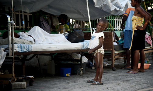 BARNELEK: En liten gutt fors�ker � leke blant rekker av s�rede mennesker utenfor det offentlige sykehuset i Port-de-Prince. Han ser ikke ut til � ense den stramme liklunkten. FOTO: �ISTEIN NORUM MONSEN