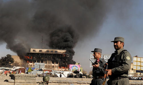I BRANN: Afghanske soldater holder utkikk i n�rheten av en av bygningene som er rammet i angrepene. Kabul. Foto: AFP PHOTO/SHAH Marai/Scanpix