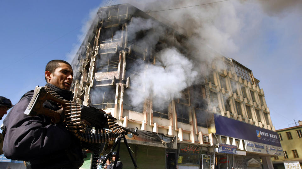 ANGREPET: En afghansk politimann st�r ved et av de to kj�pesenterene som ble angrepet. Foto: REUTERS/Omar Sobhani/Scanpix