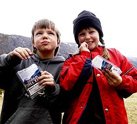T�rket kj�tt: Lars (8) og Lisa (10) Skiaker spiser t�rket, marinert kj�tt, nok en spesialitet fra Skj�k. I bakgrunnen er mamma Liv-Marit, som med mannen Leif Skiaker st�r bak ideen med marinert, t�rket kj�tt.
