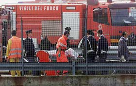 OMKOMMET: Politi og ambulansepersonell b�rer vekk en av de omkomne. S� langt har de ikke funnet overlevende i de to flyene.
