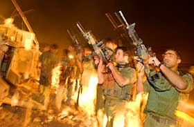 T�MMER V�PNENE:  Israelske soldater tar ut ammunisjonen fra sine v�pen etter at de har forlatt Gaza s�ndag kveld.