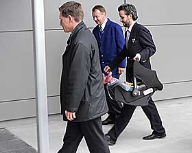 DRO: 
Ari Behn, b�rende p� datteren Maud Angelica og tett fulgt av politi og personale fra OSL p� Oslo lufthavn Gardermoen i formiddag, hvor de sammen med prinsesse M�rtha Louise tok plass p� direktefly til New York.