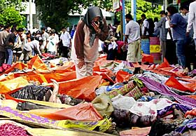 FORTVILT: En kvinne fra Aceh-provinsen leter etter sine egne blant de mange d�de som var funnet etter flodb�lgen.