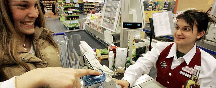 FORN�YDE KUNDER: Selv om enkelte frykter for sikkerheten rundt de lagrede fingeravtrykkene er b�de butikk-kjeden og kundene s� forn�yde at Edeka lanserer betalingssystemet over hele Tyskland fra april i �r. Her smiler Miriam Kleck seg gjennom betalingsprosedyren.