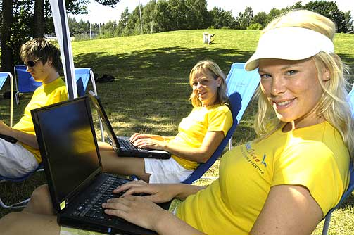 KOSER SEG: Linda Sannesmoen og Anne Wisbech koser seg p� jobb. Med 3G-kort p� laptoppen og mobiltelefon, kan de gj�re eksakt det samme ute som inne p� kontoret.