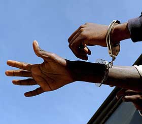 P�GREPET OG SENDT TILBAKE: En afrikansk flyktning roper p� vann fra bussen som skal frakte ham til den marokkanske interneringsleiren.