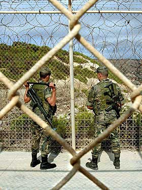 STILLE ETTER STORMEN: To spanske soldater vokter grensen mellom Melilla og Marokko 15. oktober. Etter flere uker med voldsom uro og kamper er det relativt stille ved grensegjerdet.