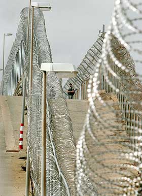 DOBBELT S� H�YT GJERDE:  Akkurat n� p�g�r arbeider for � gj�re gjerdet rundt Melilla dobbelt s� h�yt.Samtidig �ker kritikken mot spanske og marokkanske myndigheter for brudd p� menneskerettighetene.